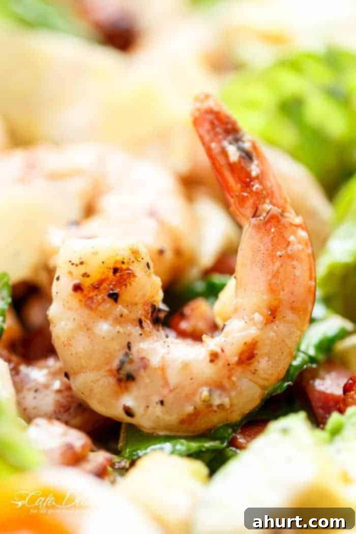 Close up image focusing on a grilled lemon garlic shrimp with a slight char