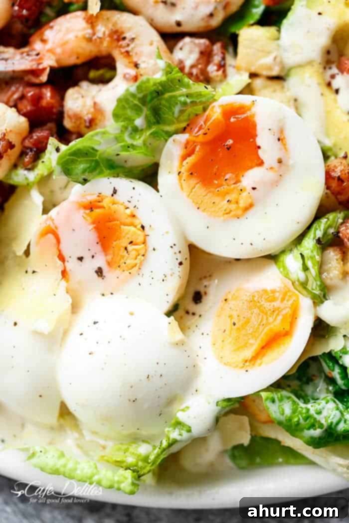 Close up image focusing on a soft boiled egg in Skinny Lemon Garlic Shrimp Caesar Salad