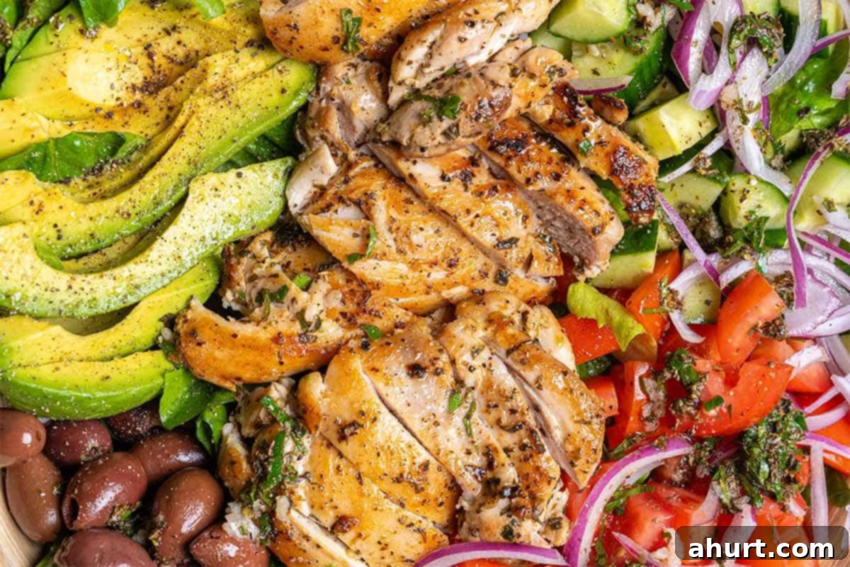 Mediterranean Grilled Lemon Herb Chicken Salad 7 Close-up of a vibrant Mediterranean chicken salad, tossed with dressing and fresh ingredients
