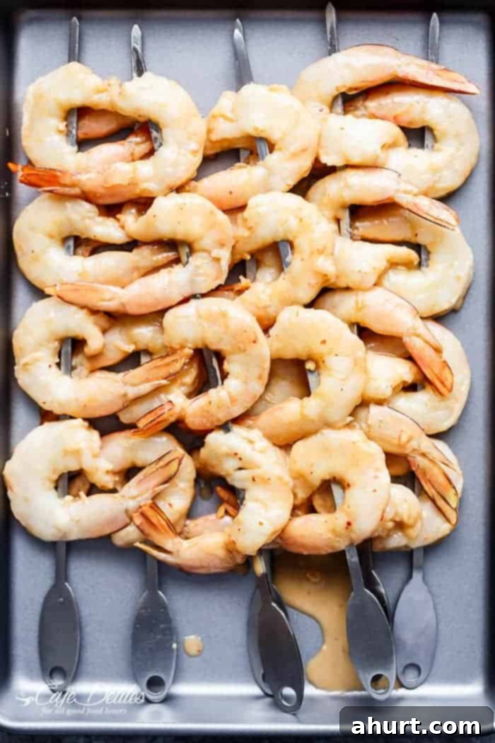 Raw shrimps in skewers on a baking tray 
