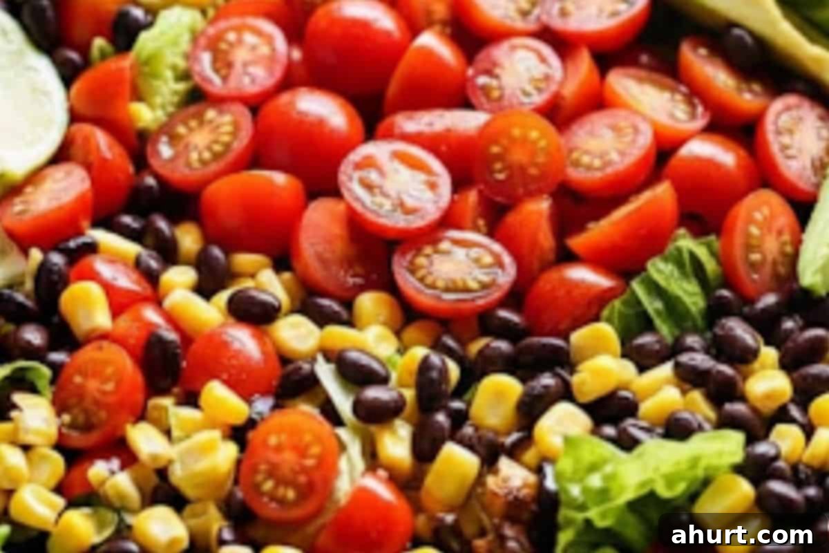 Fiery Fiesta Chicken Salad 8 Arrange romaine lettuce, halved tomatoes, avocado slices, black beans, and corn in a large serving bowl.