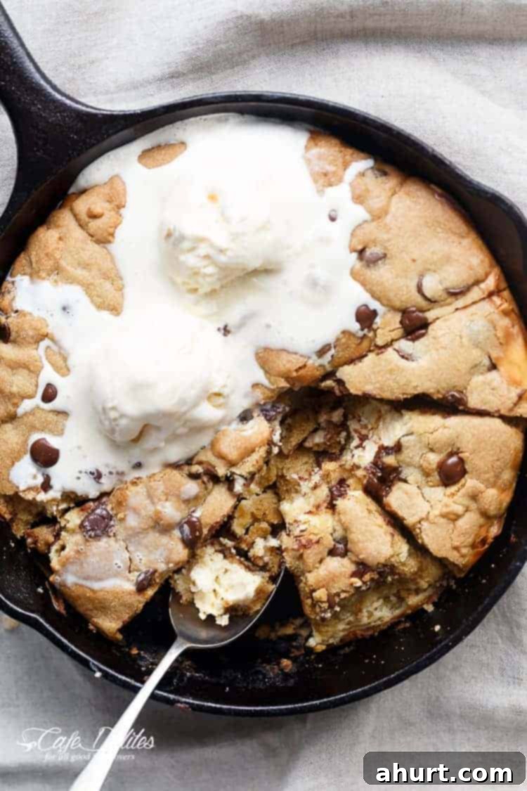 Cheesecake Stuffed Pizookie 7 A crispy, soft Cheesecake Stuffed Chocolate Chip Skillet Cookie cut into pieces with some ice cream scoops