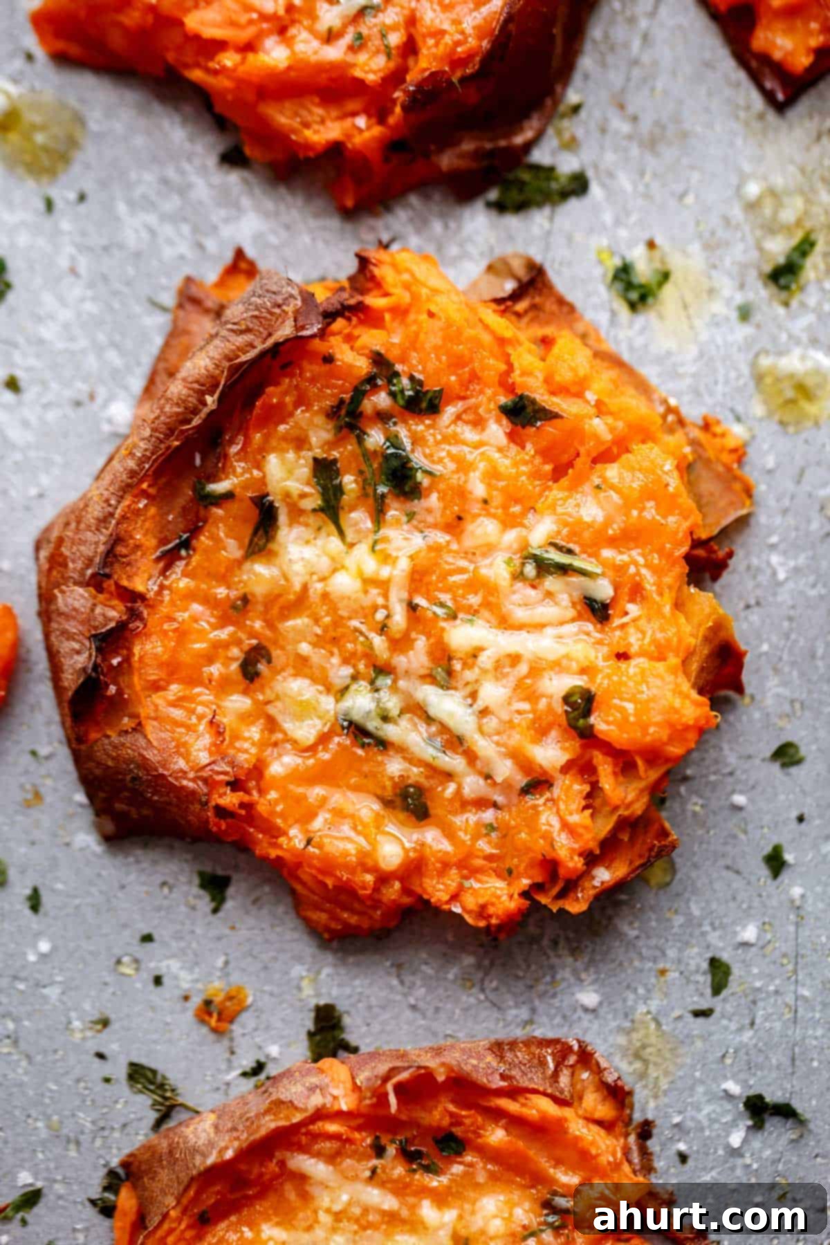 Golden Garlic Parmesan Smashed Sweet Potatoes 3 Top view Image of a single slice of grilled, smashed sweet potato with parmesan and parsley.