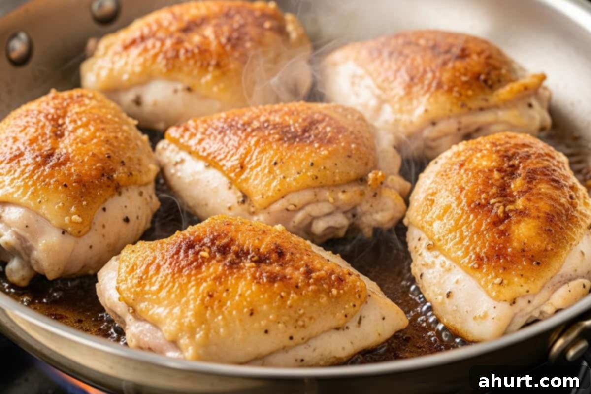 Luscious Creamy Garlic Parmesan Chicken 5 Seared chicken thighs, skin-side down, sizzling in a hot oven-proof skillet.