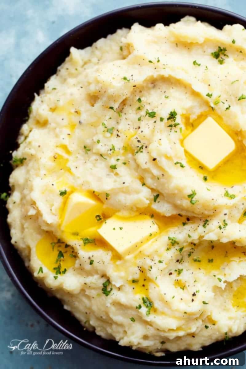 Zoom in image of Creamy Slow Cooker Mashed Potatoes with a hint of garlic and parmesan cheese, served in a bowl.