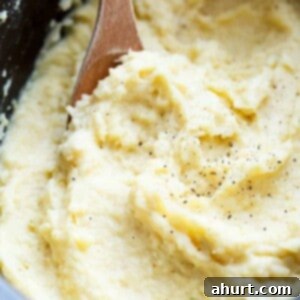 Creamy Slow Cooker Mashed Potatoes with wooden spoon