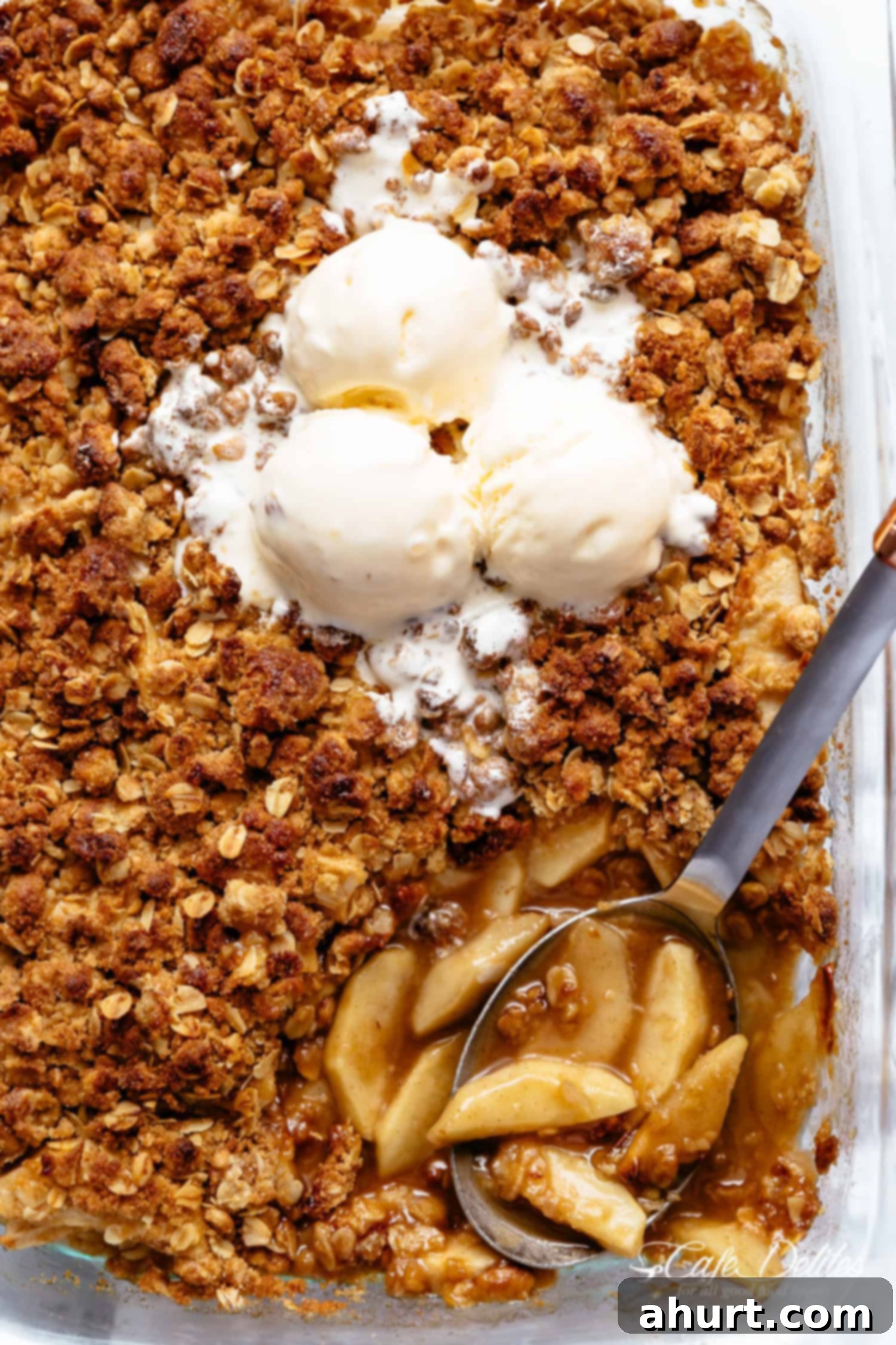 Apple crumble scoop in a baking dish with ice cream #apple #fall #thanksgiving #crumble #crisp #applecrumble #icecream Easy Cinnamon Apple Crumble with ice-cream is foolproof! A juicy apple pie filling is covered with a crispy oatmeal cookie-like topping! BEST apple crumble!