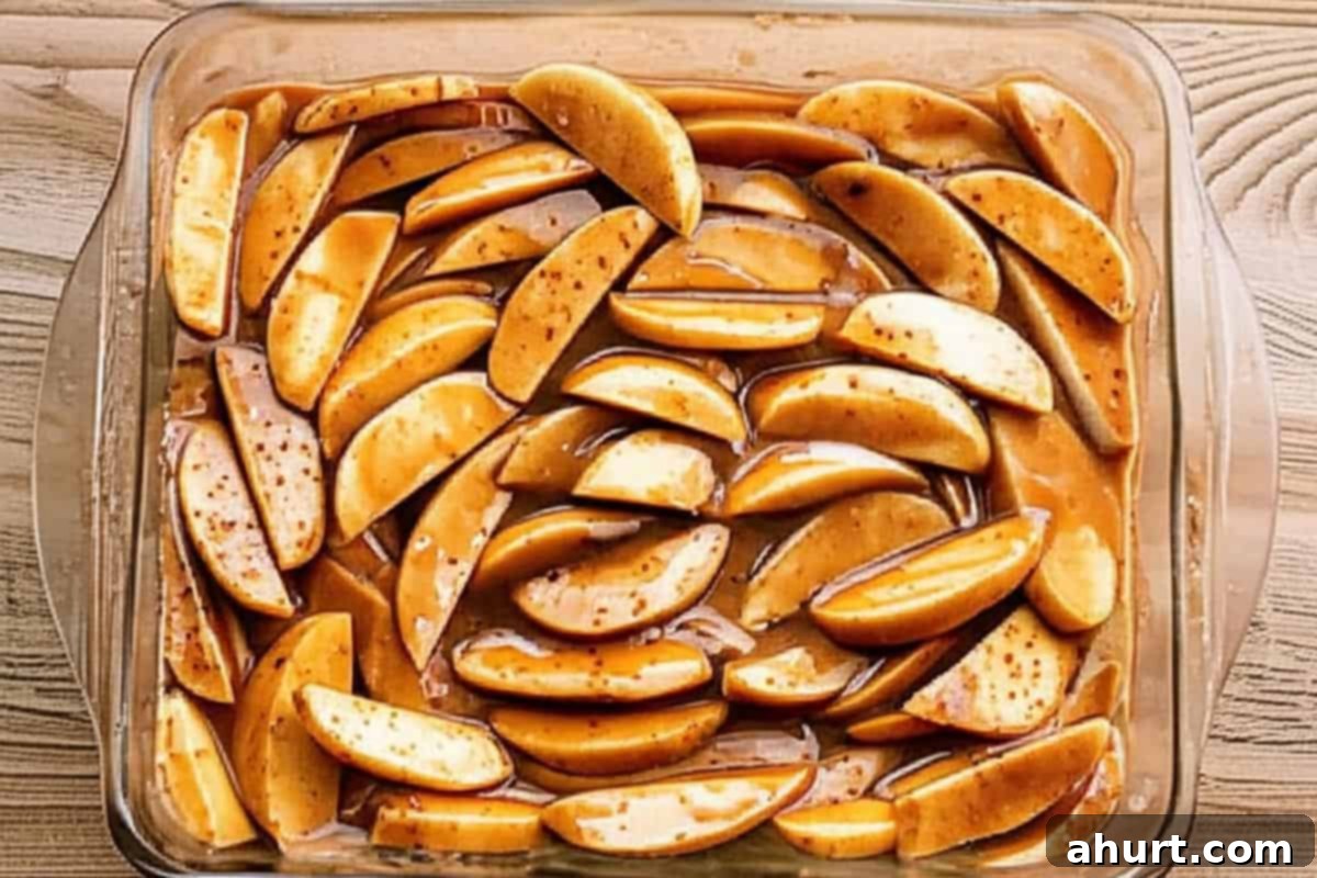 Effortless Apple Crumble 3 Sliced apples mixed with sugars, flour, cinnamon, and water in a baking dish.