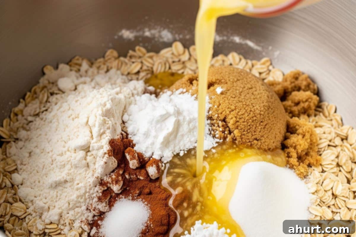 Effortless Apple Crumble 4 A bowl with oats, flour, both sugars, cinnamon, salt, baking powder, and butter being poured.