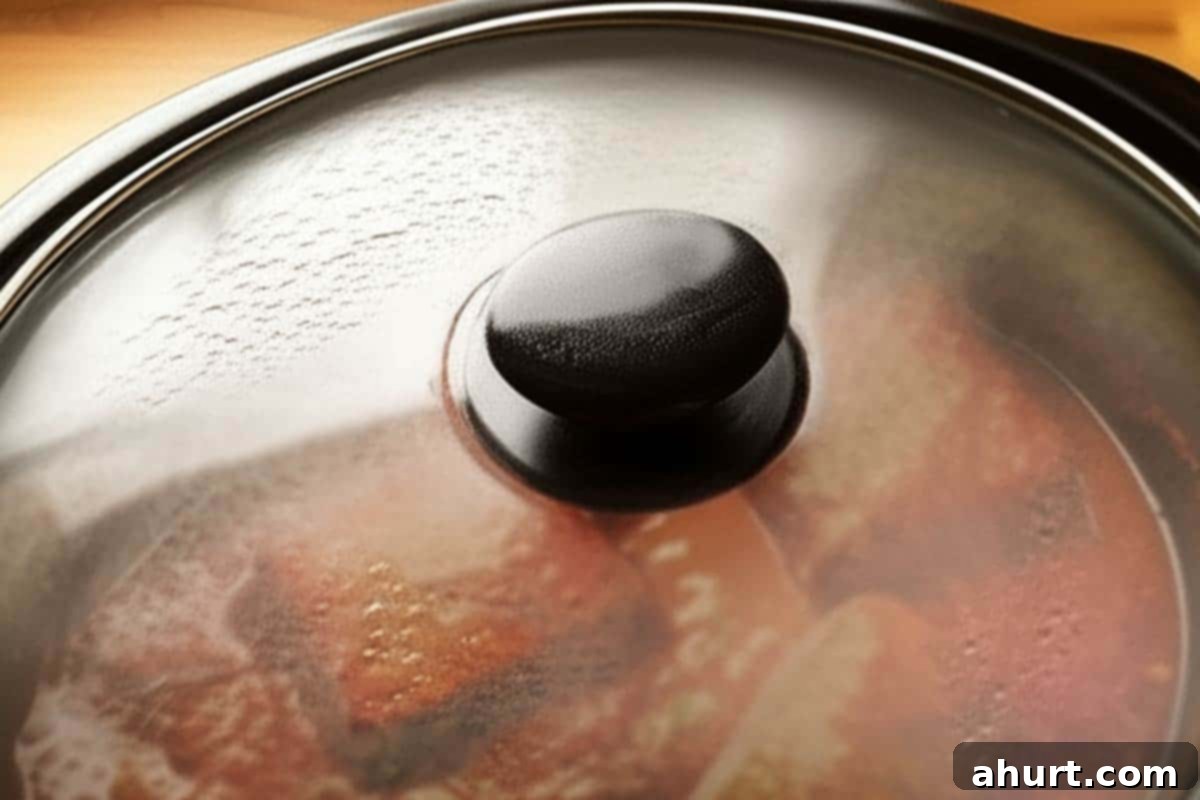 Fall-Apart Tender Slow Cooker Beef Ragu 8 A slow cooker with its lid firmly in place, actively cooking the rich beef ragu to tender perfection.