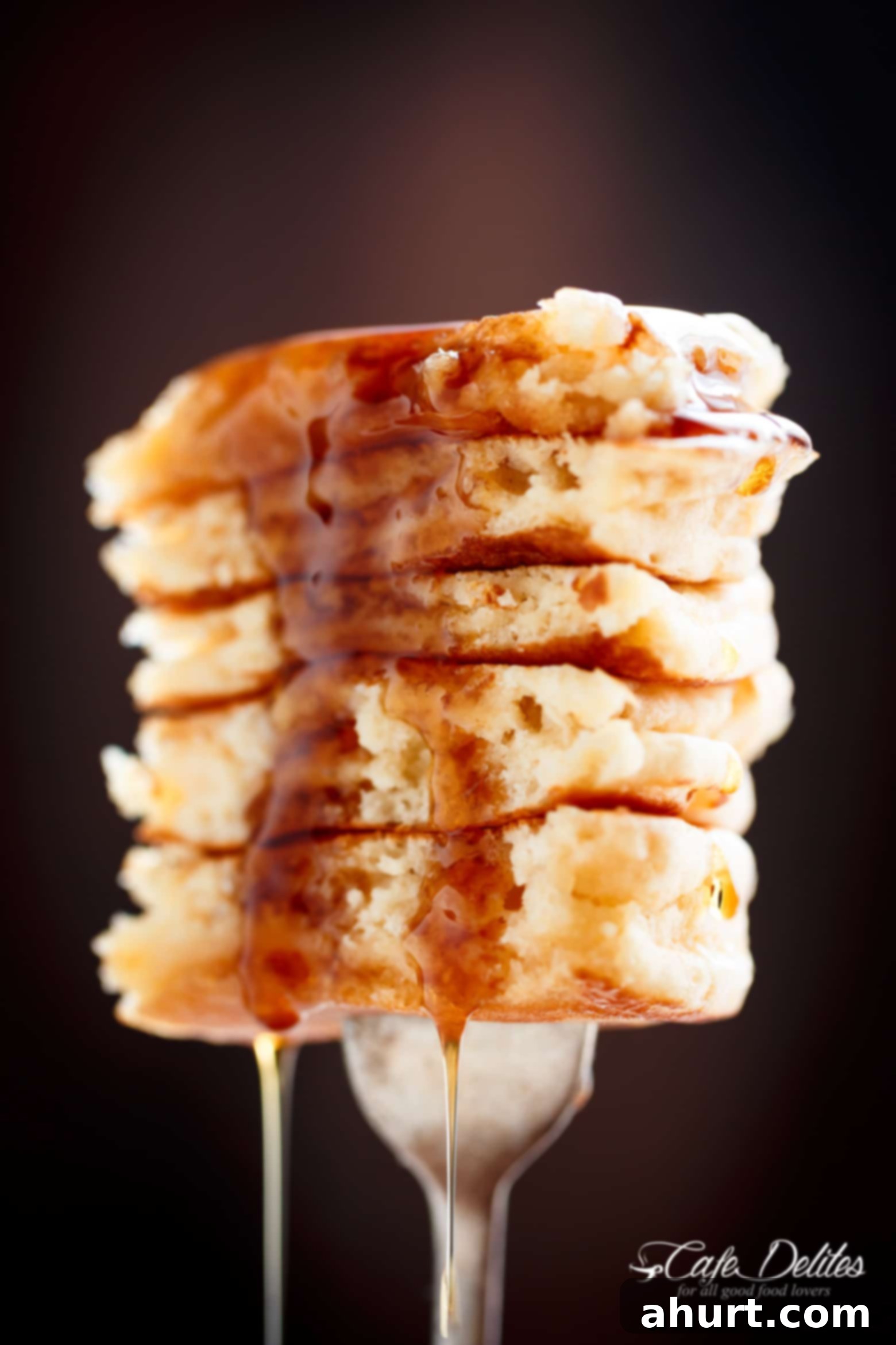Irresistibly Fluffy Pancakes 3 A piece of Best Fluffy Pancakes on a fork, showcasing its light and airy texture. Weekends will never be the same again!