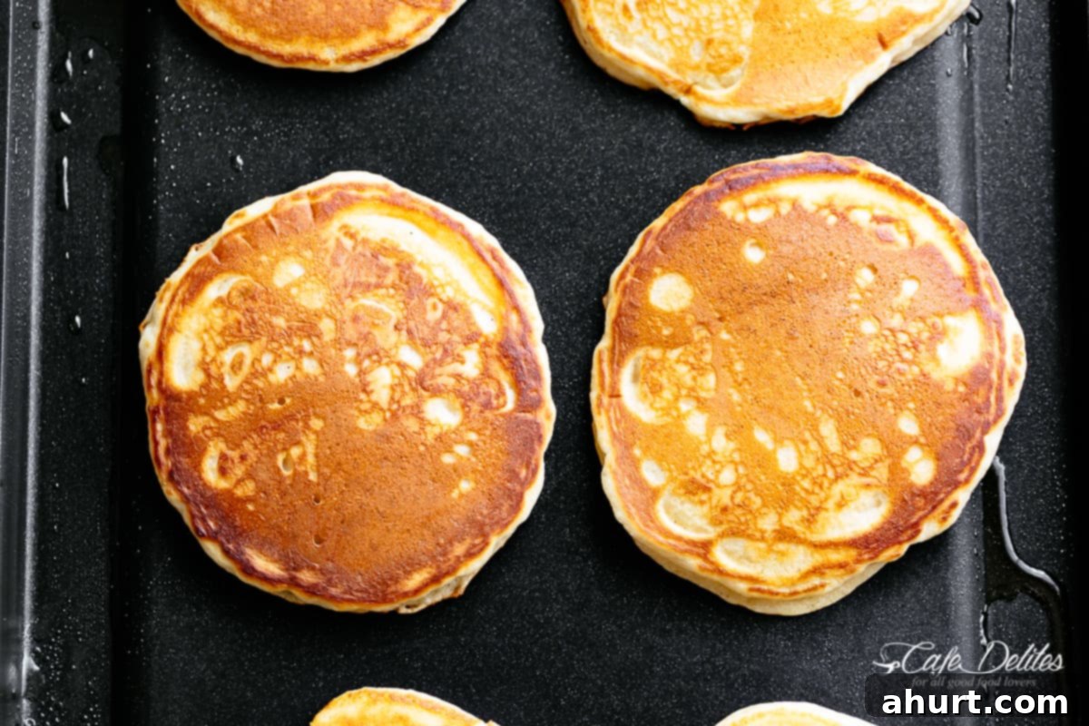 Irresistibly Fluffy Pancakes 4 How to make the best fluffy pancakes, showing the bubbling batter before flipping.
