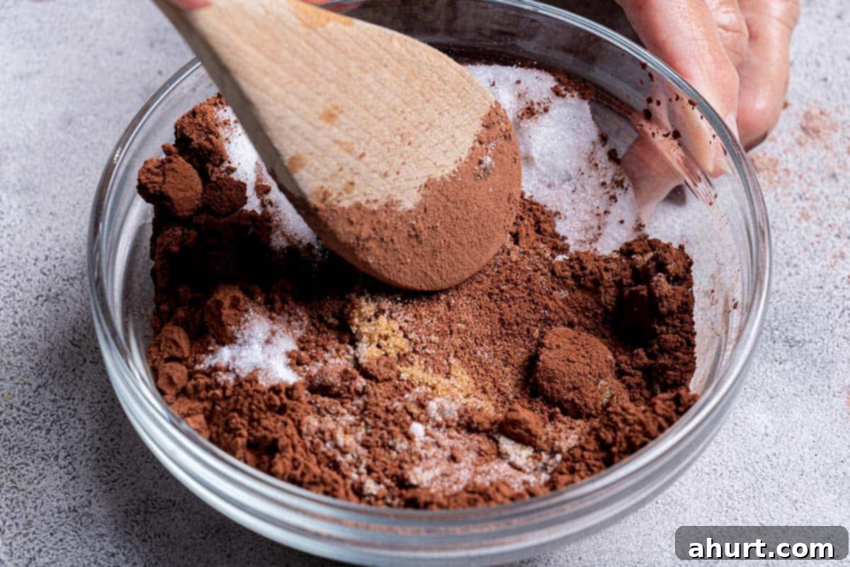 Molten Chocolate Fudge Pudding Cake 6 dry ingredients being mixed into a bowl close up white sugar, brown sugar and cocoa powder