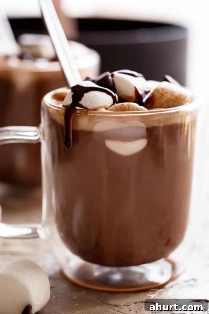 Comforting Hot Chocolate 3 Side view image of Special Ingredient Hot Chocolate in a cup, topped with mini marshmallows and chocolate shavings.