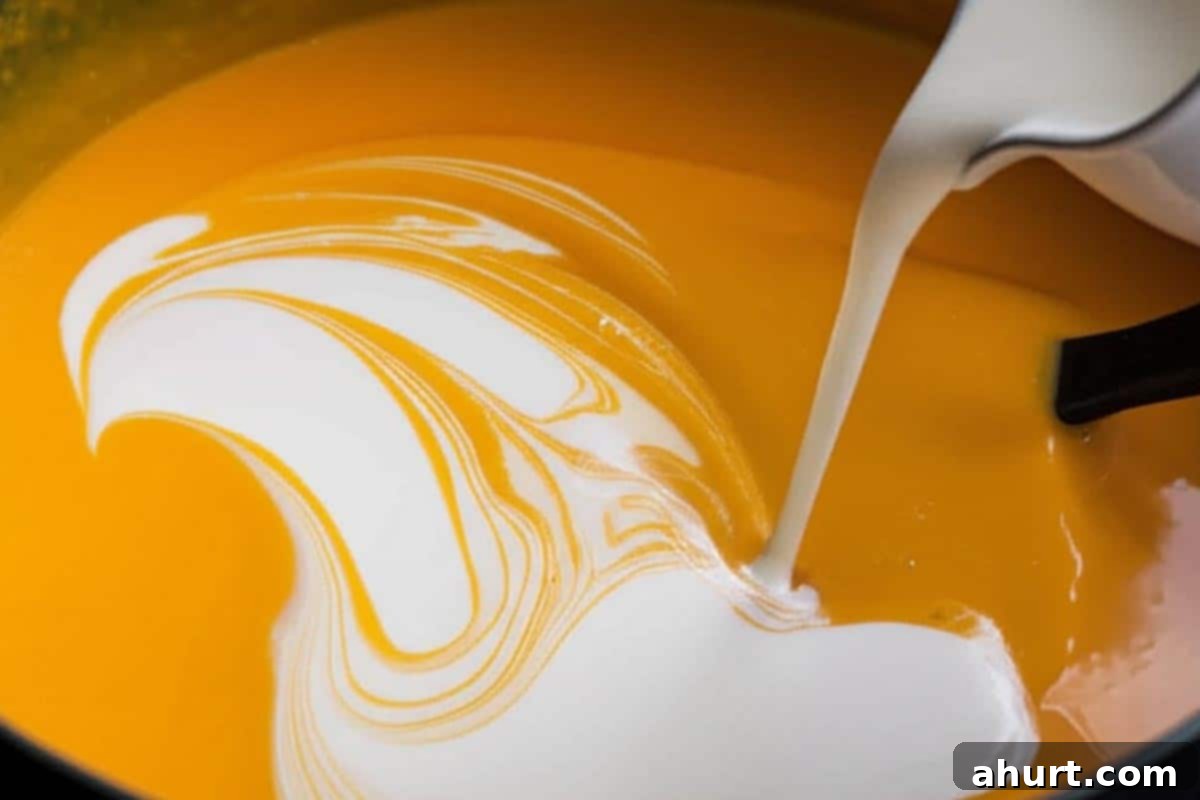 Velvety Golden Pumpkin Soup 7 Adding cream to the soup.