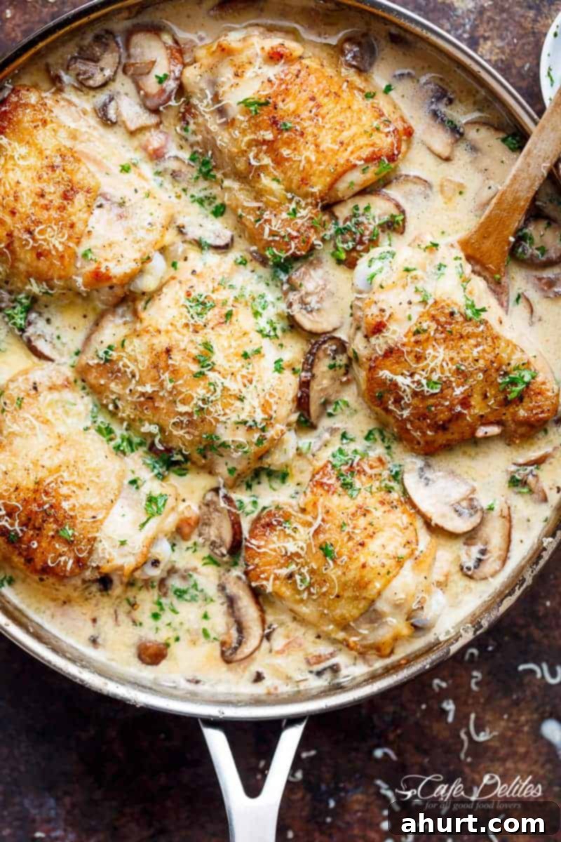 Creamy Parmesan Herb Mushroom Chicken in a pan, garnished with fresh herbs and ready to serve