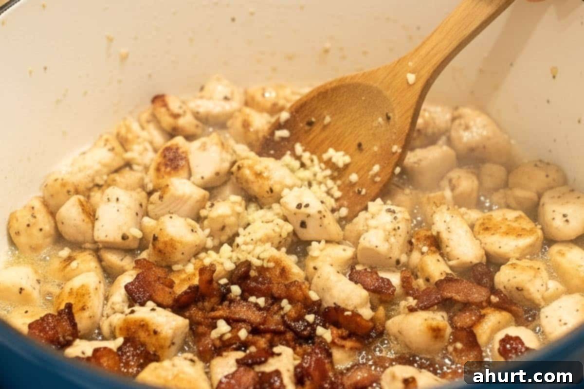 Easy One Pot Chicken Bacon Fettuccine Alfredo 5 Diced chicken added to the pot with crispy bacon, cooking until perfectly browned and tender.