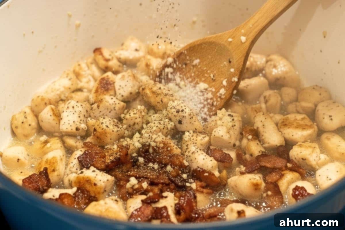Easy One Pot Chicken Bacon Fettuccine Alfredo 6 Salt and pepper sprinkled over the chicken and bacon mixture in the pot, ready to be stirred.