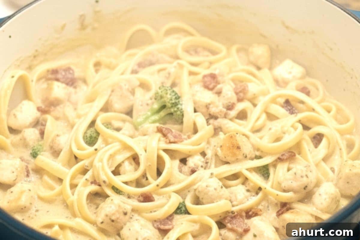 Easy One Pot Chicken Bacon Fettuccine Alfredo 10 Pasta and broccoli cooking until al dente, creating a rich and creamy sauce.