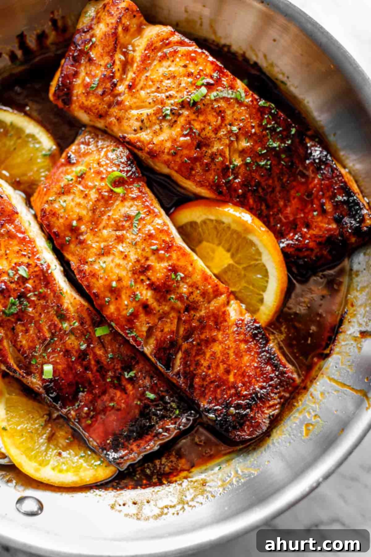 Three pieces of Crispy Honey Orange Glazed Salmon, ready to be served, showcasing their perfect sear and glaze.