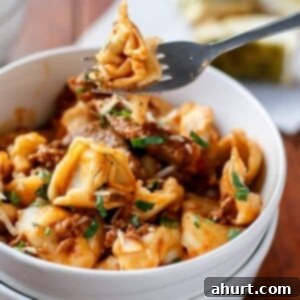 Hearty Beef Tortellini with Chunky Sauce 13 Fork holding a piece from Tortellini with Chunky Beef Sauce
