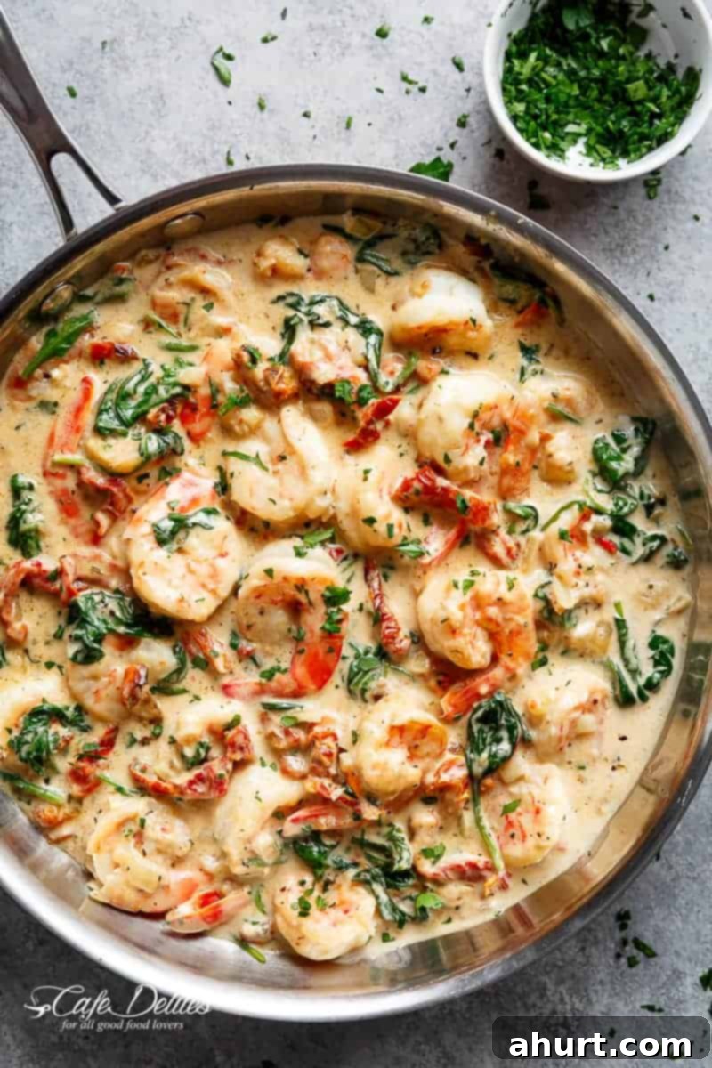 Creamy Tuscan Garlic Butter Shrimp 2 Creamy Garlic Butter Tuscan Shrimp coated in a light and creamy sauce filled with garlic, sun dried tomatoes and spinach in a pan.