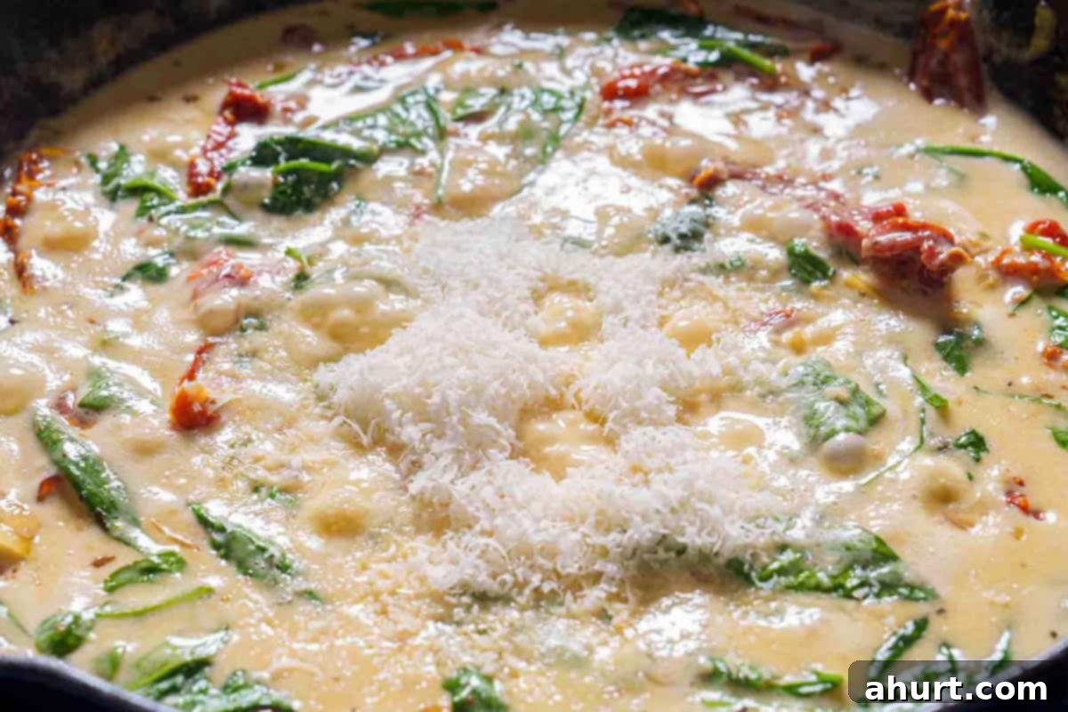 Creamy Tuscan Garlic Butter Shrimp 7 An image shows spinach and cheese being added to the mixture to create the sauce.