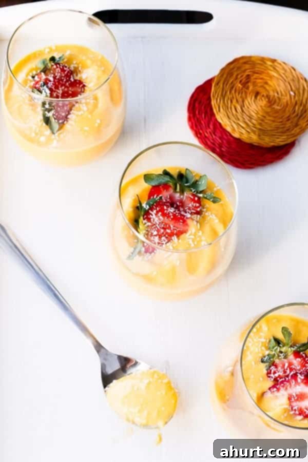 Top-down view of a trio of Coconut Mango Cheesecake Parfaits, showcasing the vibrant colors and creamy texture.