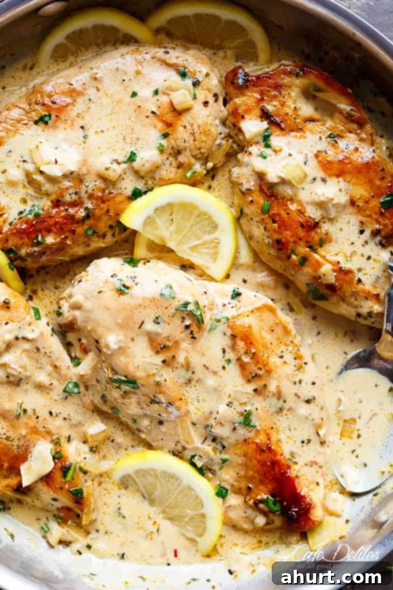 A vibrant and appetizing close-up of Lemon Chicken Scallopini with Lemon Garlic Cream Sauce, garnished with fresh herbs and lemon slices.