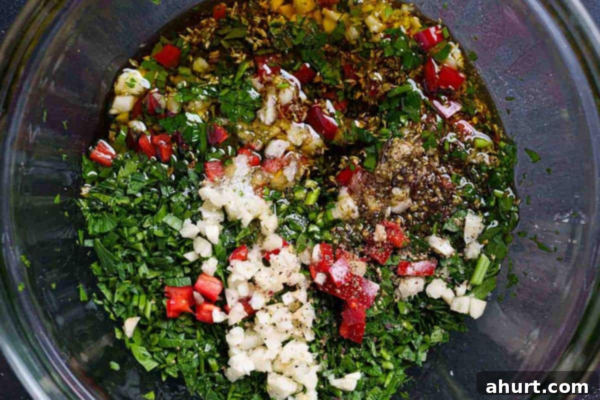 The Authentic Chimichurri of Uruguay and Argentina 5 The image shows olive oil, red wine, vinegar, and oregano being added to the mixture of previously chopped ingredients.
