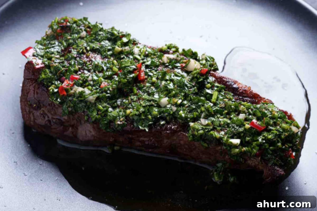 The Authentic Chimichurri of Uruguay and Argentina 7 An image of a beautiful rump steak topped with finely chopped chimichurri, with oil pouring from it.
