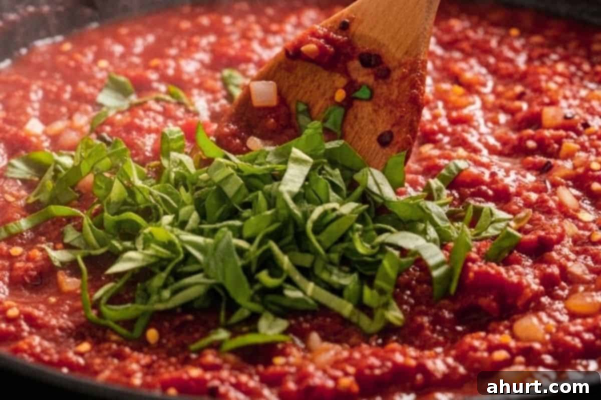 Irresistible Cheesy Meatballs 10 Stir in tomato puree, water, tomato paste, basil, oregano, chili flakes, salt, and pepper and bring to a simmer.