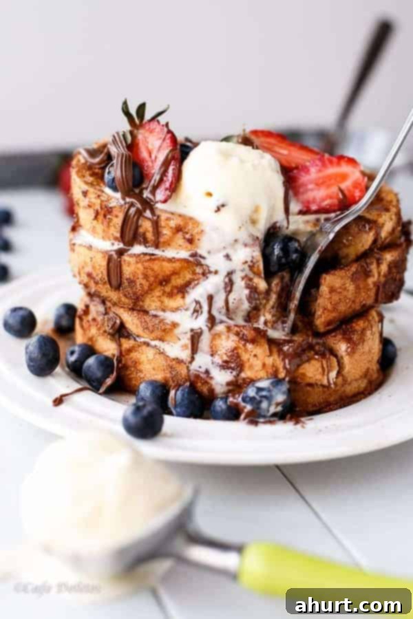 Nutella Stuffed Churro French Toast with ice cream and fresh berries on a plate