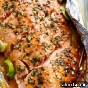 Zesty Honey Lime Garlic Butter Salmon 5 Honey Lime Garlic Butter Salmon in foil, a perfectly cooked fillet garnished with fresh herbs