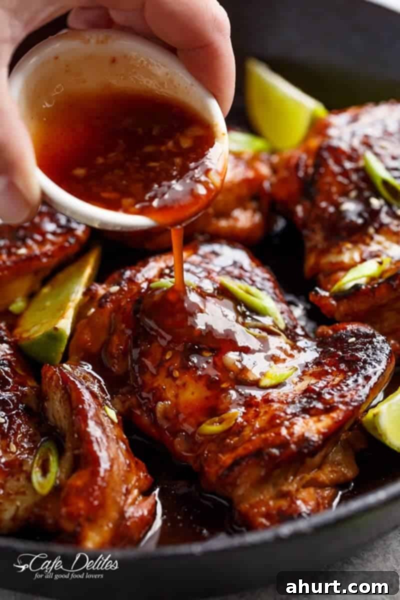 Honey Sriracha Glazed Chicken 12 Sriracha sauce being poured generously on a plate of Honey Garlic Sriracha Chicken, enhancing its fiery appeal.