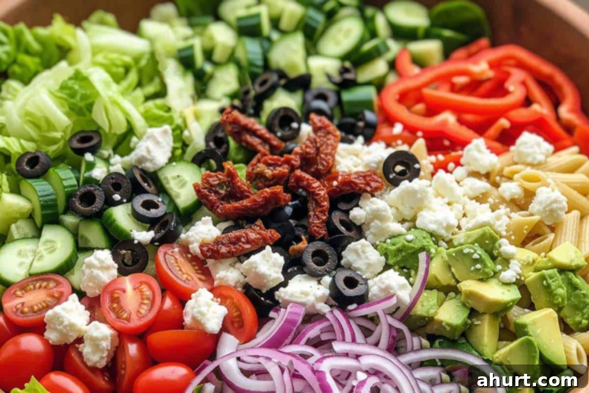 Zesty Mediterranean Pasta Salad 6 Lettuce, cucumber, avocado, red pepper, tomatoes, onion, olives, sun-dried tomatoes, and feta in the bowl with pasta.