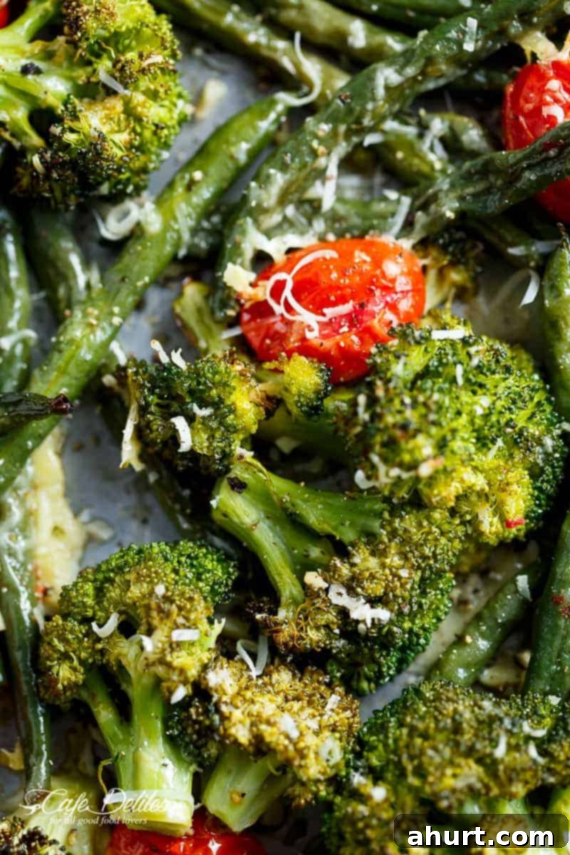 One-Pan Garlic Parmesan Roasted Broccoli and Green Beans 5 Focusing on broccoli and tomato piece from Sheet Pan Garlic Parmesan Roasted Broccoli & Green Beans