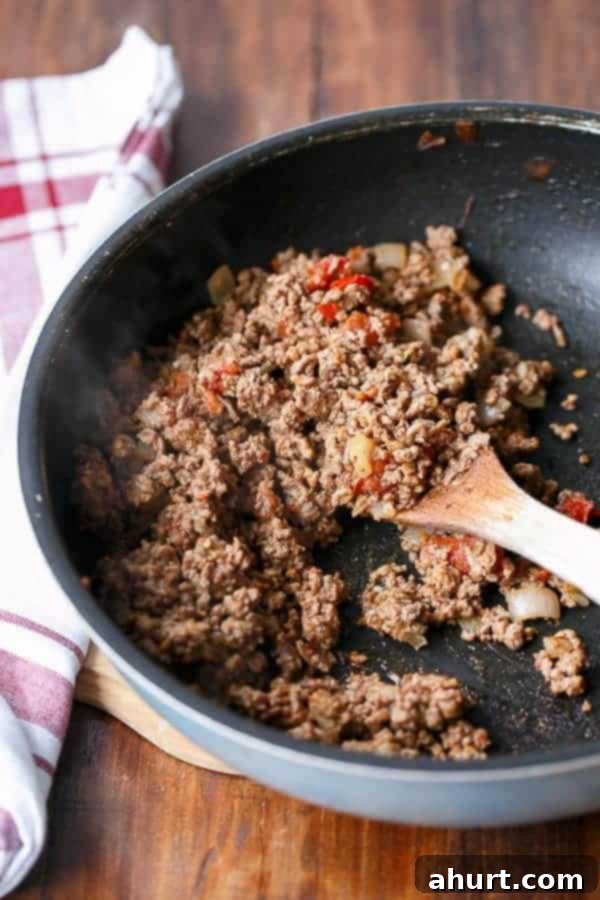 Close-up of taco mince mixture being prepared in a pan, highlighting fresh ingredients.