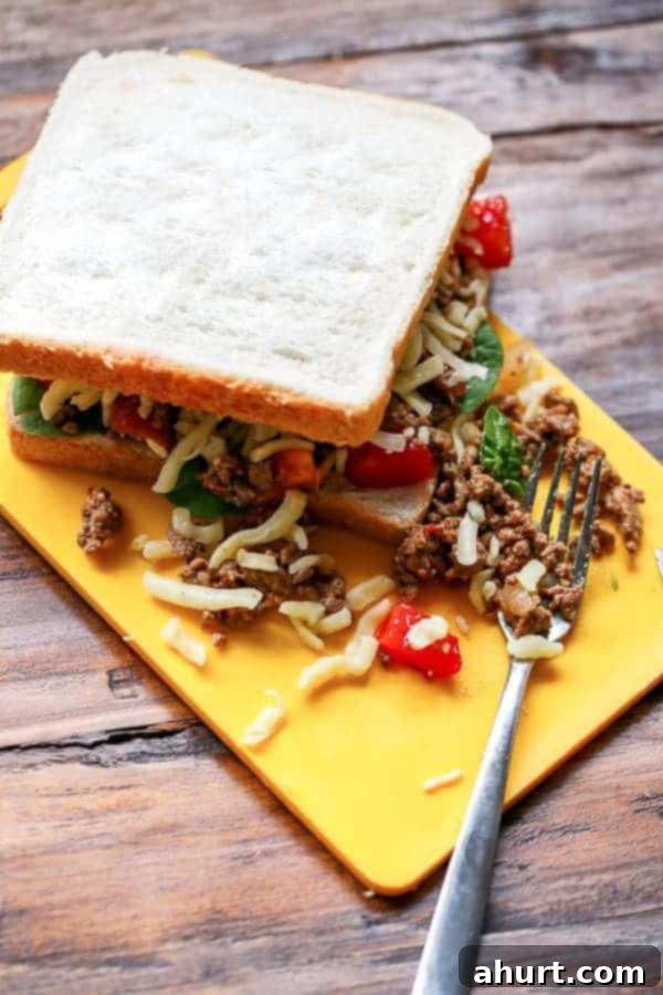 Taco Grilled Cheese sandwich generously loaded with all the ingredients, ready for grilling.