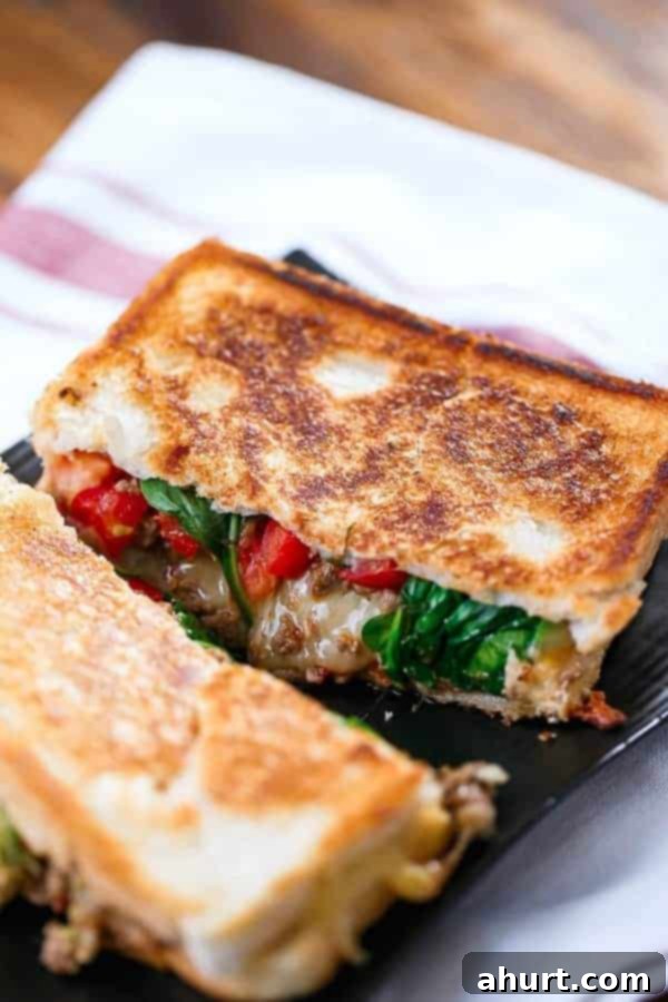 Loaded Taco Grilled Cheese sandwich cut into halves, revealing the rich layers of filling and melted cheese.