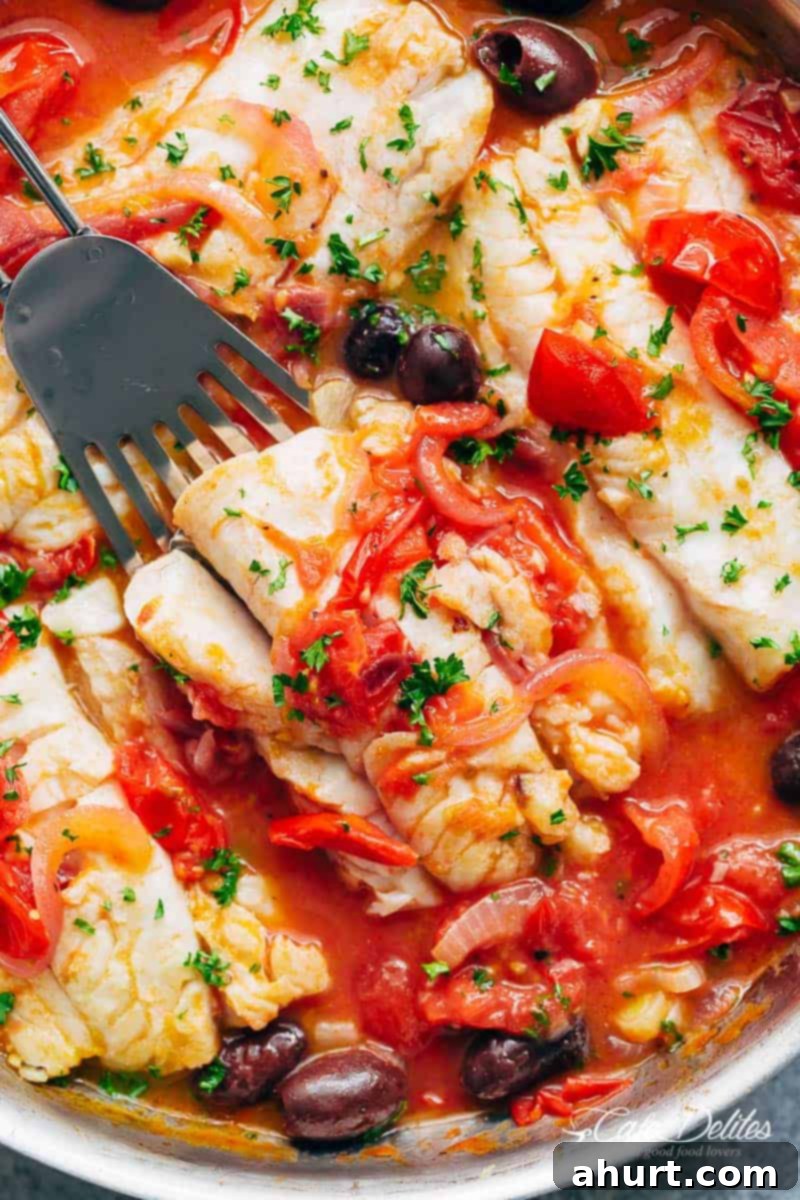 Pan Seared Fish With Tomatoes & Olives simmering gently in a pan, close-up of the sauce