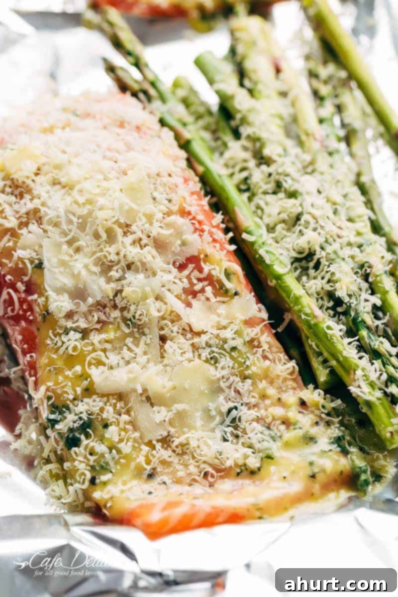 Zesty Lemon Parmesan Salmon and Asparagus Foil Packets 4 Freshly grated parmesan cheese generously sprinkled over salmon and asparagus in a foil packet, ready for baking or grilling.
