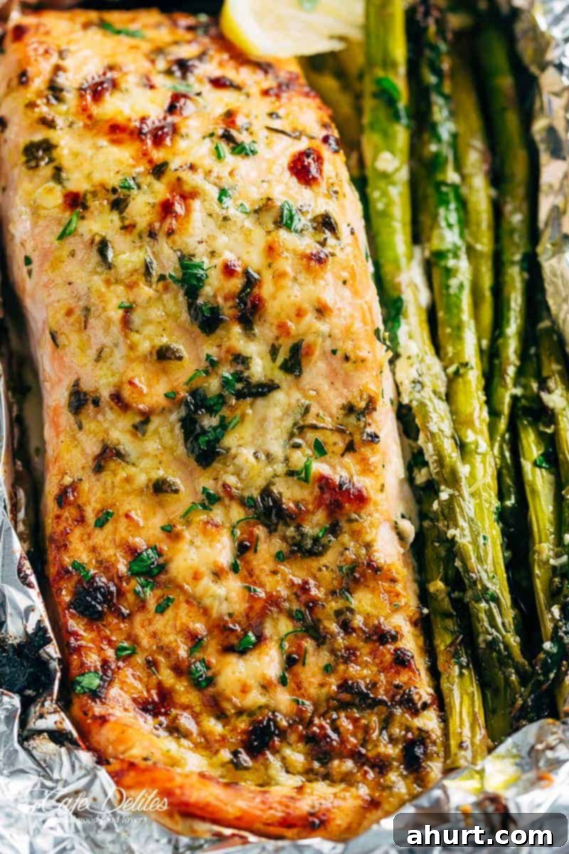 Zesty Lemon Parmesan Salmon and Asparagus Foil Packets 5 Two fully cooked Lemon Parmesan Salmon & Asparagus Foil Packs opened, showing the perfectly flaky salmon and tender asparagus, garnished with fresh parsley.