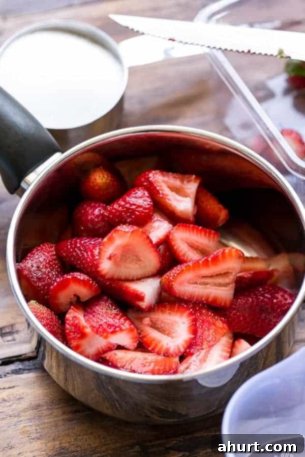 Close-up of fresh, ripe strawberry pieces in a pan, ready for making the conserve.