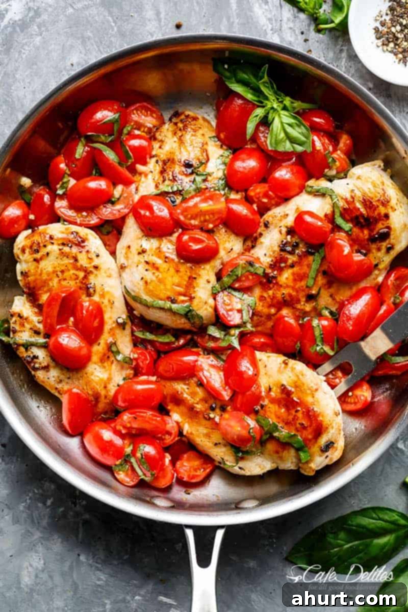 Top view of Garlic Tomato Basil Chicken in a pan, showcasing golden chicken and vibrant sauce