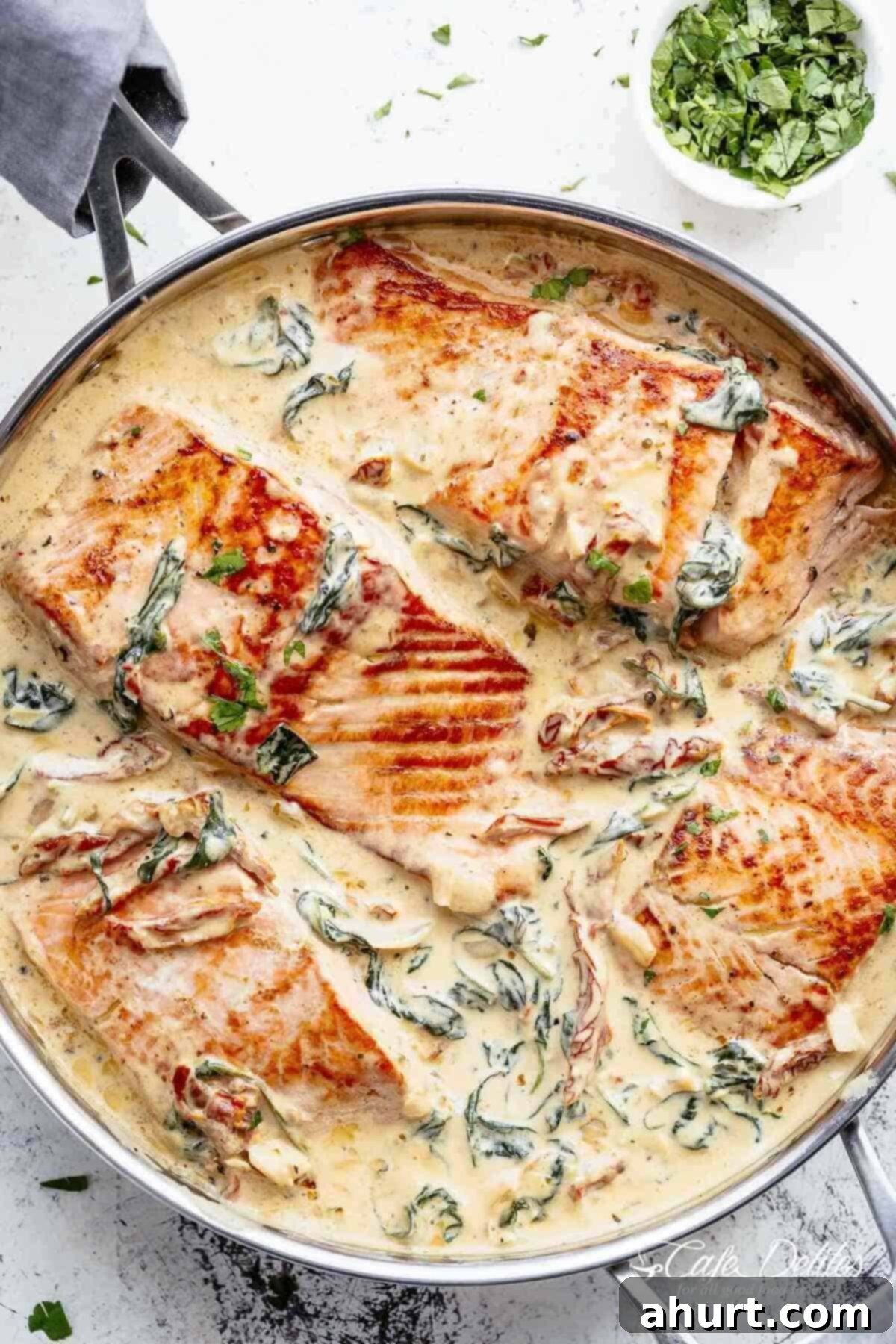 Velvety Tuscan Garlic Butter Salmon 2 Close-up image of creamy garlic butter Tuscan salmon in a pot, showcasing its rich texture and vibrant colors.
