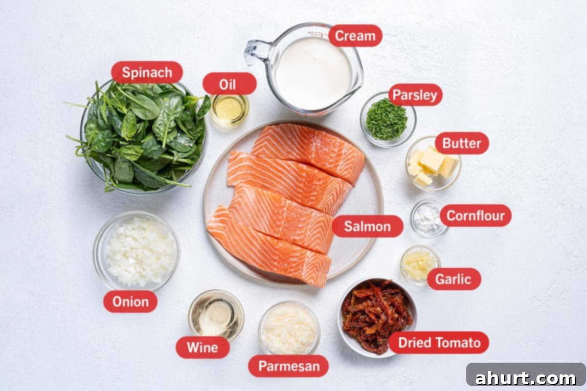 Velvety Tuscan Garlic Butter Salmon 3 A flat lay image displaying all the key ingredients for Creamy Garlic Butter Tuscan Salmon: fresh salmon fillets, olive oil, heavy cream, fresh parsley, butter, cornstarch, cloves of garlic, sun-dried tomatoes, grated Parmesan, white wine, diced onion, and fresh spinach.