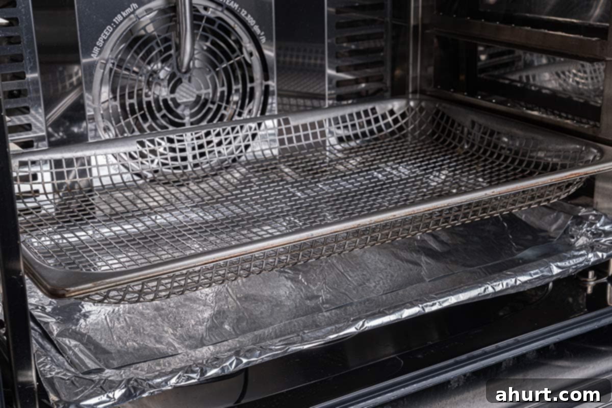 Golden Crisp Baked Buffalo Wings 4 Empty baking sheet lined with aluminum foil and topped with a wire rack, ready for chicken wings.