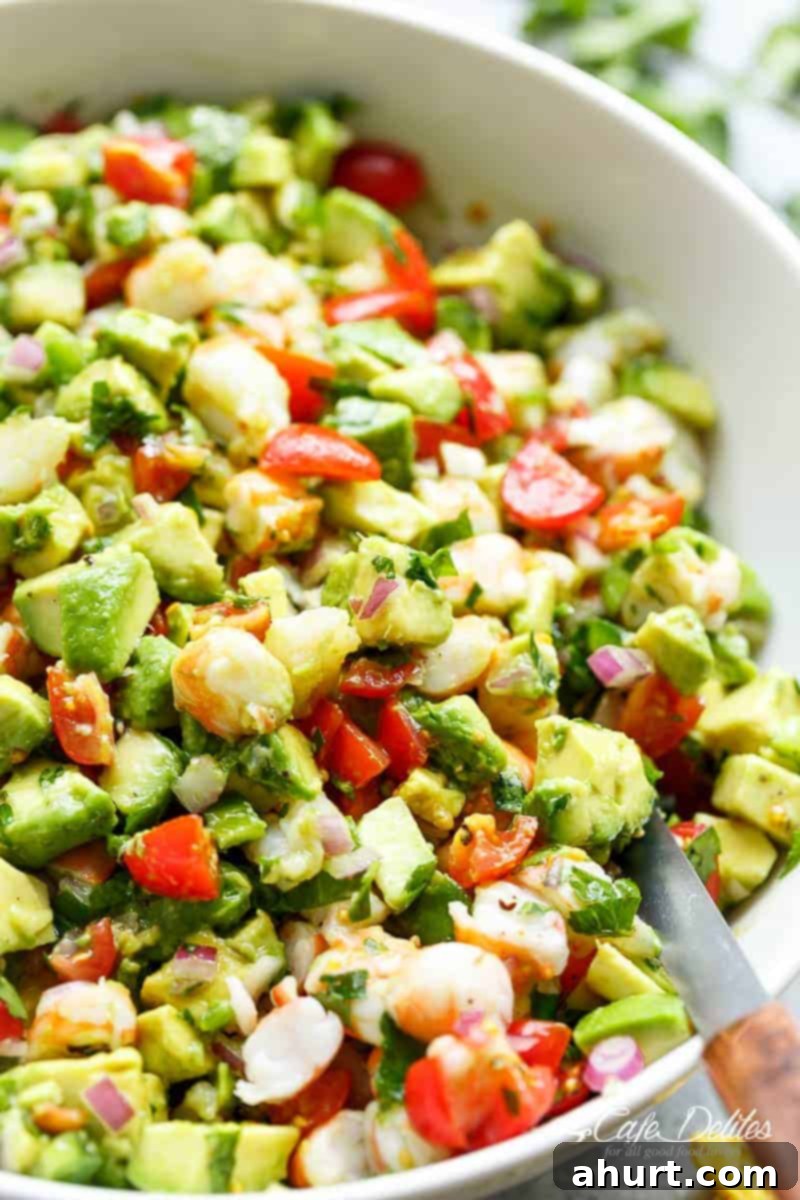Hearty Shrimp Guacamole 4 Chunky Shrimp Guacamole with spoon in a white bowl