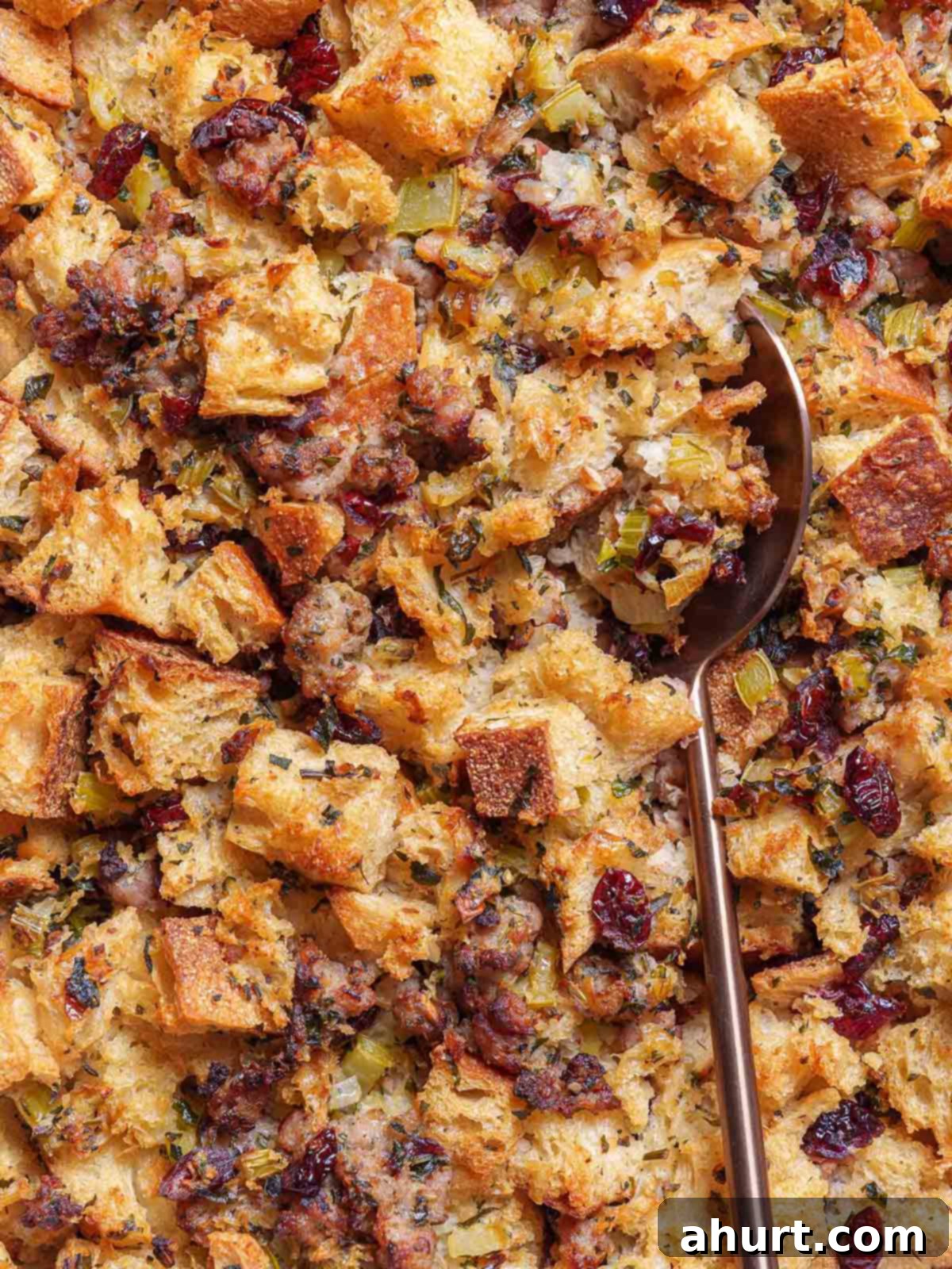 Irresistible Sausage Stuffing 2 A close-up picture of the finished sausage meat stuffing being scooped up by a golden spoon.